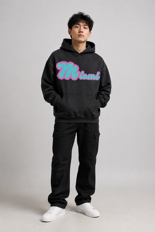 Miami Script Teal & Pink 440 GSM Heavyweight Washed Oversized Hoodie, Faded Black three-quarter front full-body men’s studio model photo, Miami | City 2 City Wear