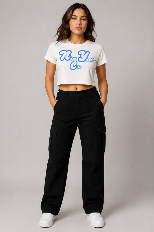 New York City Script Women’s Crop T-Shirt in White, full-body studio model wearing royal-blue and white NYC graphic crop top | City 2 City Wear