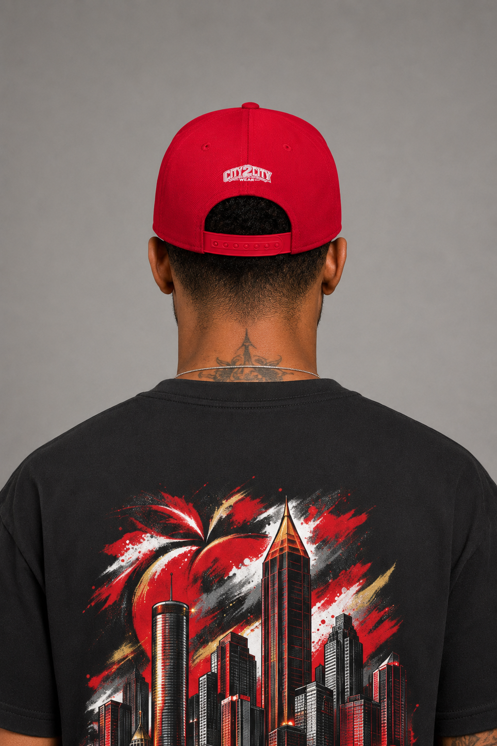 Atlanta A-Town Red Embroidered Snapback Hat — rear Atlanta model close-up showing white City 2 City Wear embroidery, red adjustable snap closure, and Atlanta skyline T-shirt | City 2 City Wear