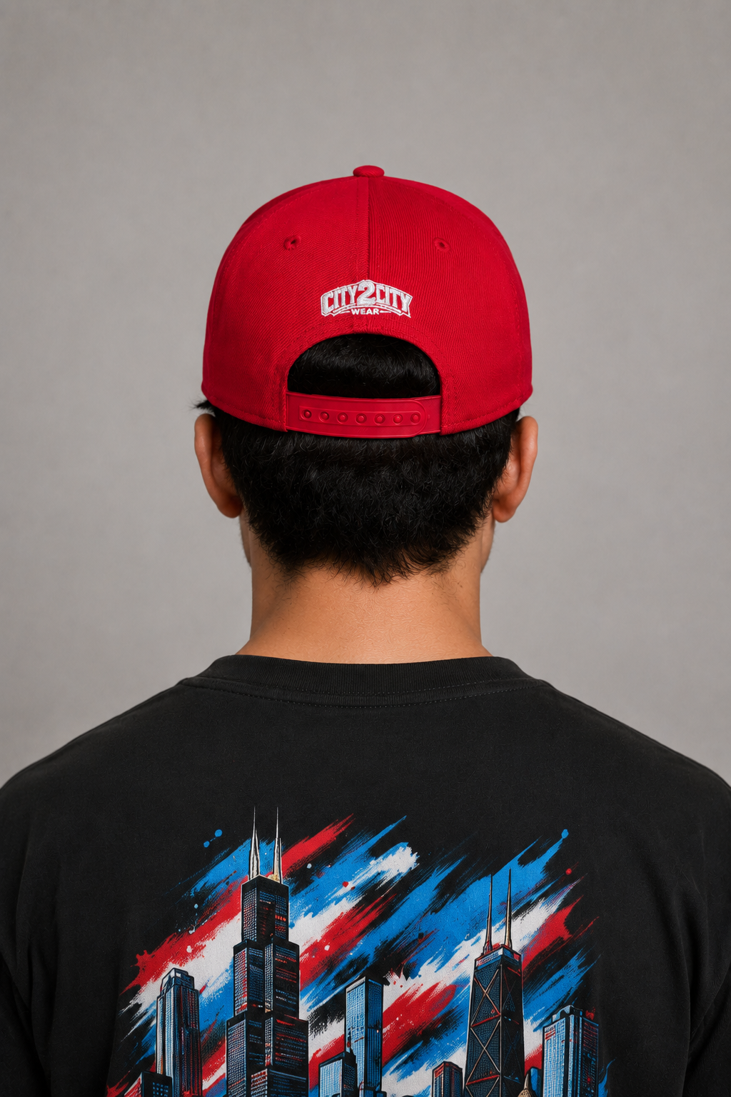 Chicago Windy City Red Embroidered Snapback Hat — rear Chicago model close-up showing white City 2 City Wear logo, red adjustable snap closure, and Chicago skyline T-shirt | City 2 City Wear