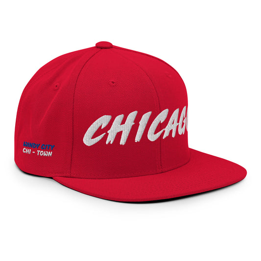 Angled view of a red Chicago snapback with white front embroidery and blue-and-white Windy City side details.