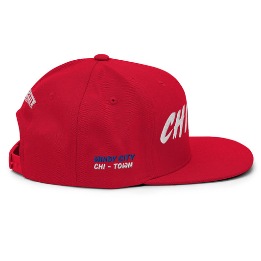 Angled view of a red Chicago snapback with white front embroidery and blue-and-white Windy City side details.