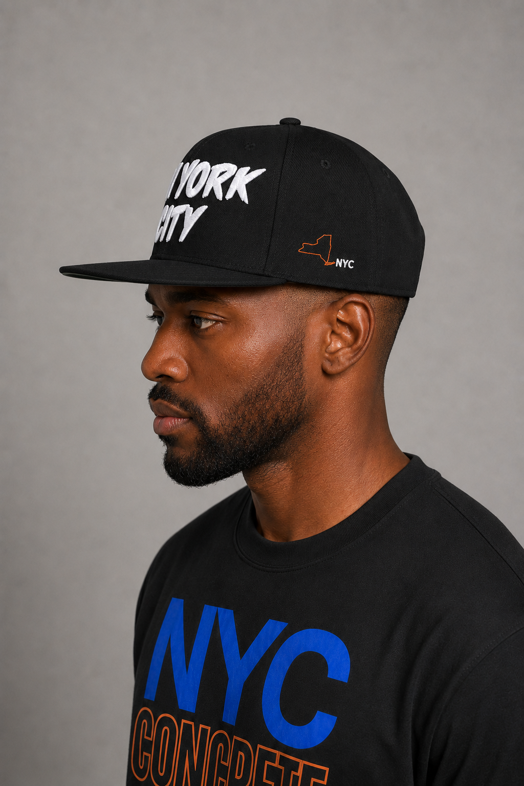 New York City Concrete Jungle Black Embroidered Snapback Hat — close-up model profile showing orange New York state outline and white NYC side embroidery | City 2 City Wear